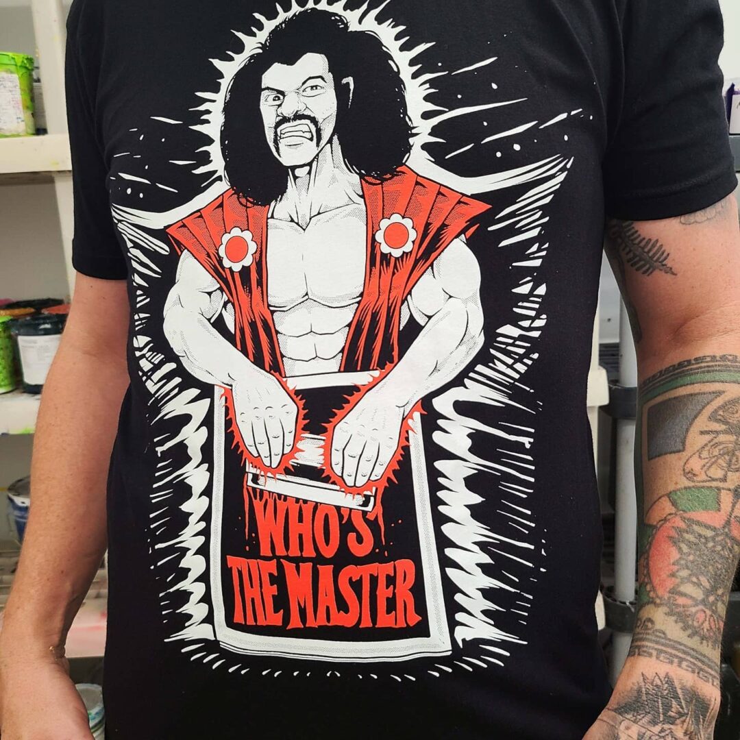 A man with tattoos wearing a shirt that says " who 's the master ".